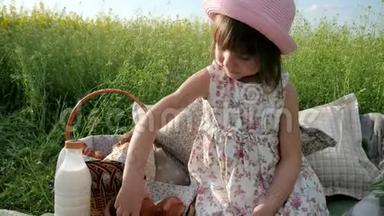 鲜花草地上可爱的女孩，带着篮子去野餐，巴拿马的女孩子，带着面包去大自然，周末野餐